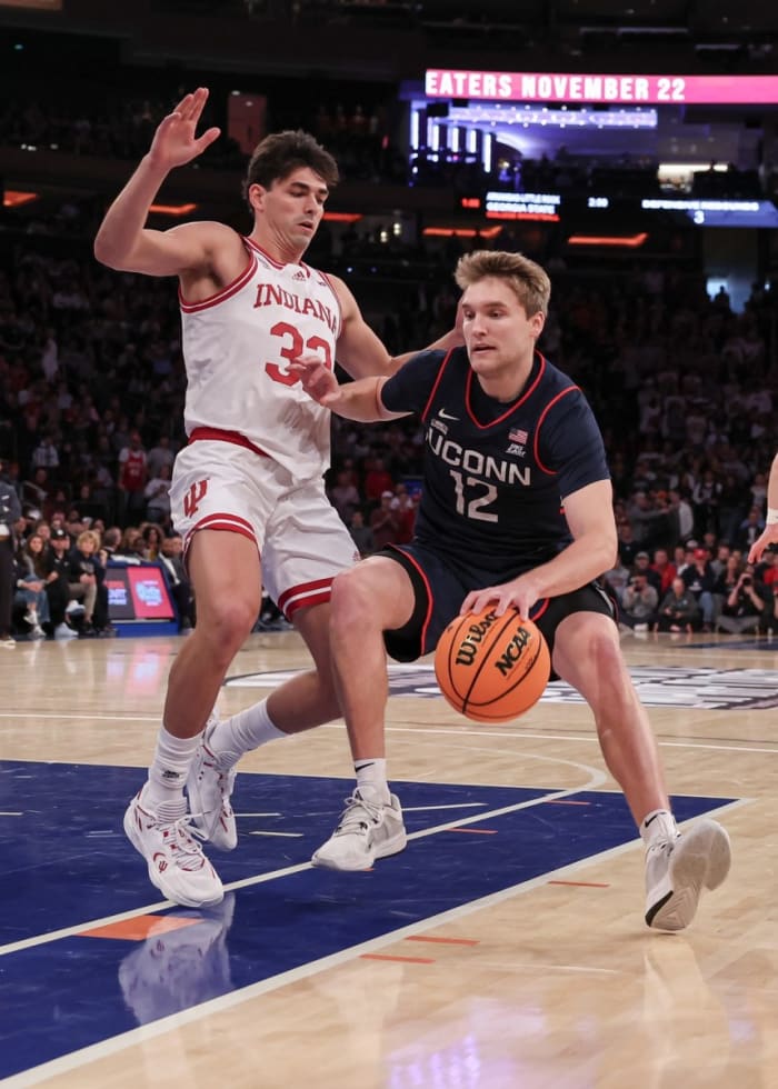 Connecticut Huskies guard Cam Spencer (12) dribbles against Indiana Hoosiers guard Trey Galloway (32) during the first half at Madison Square Garden.